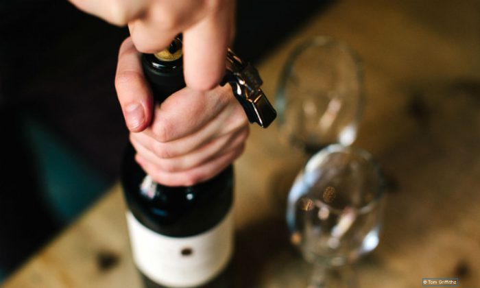 Wine bottles in a wine collection being uncorked