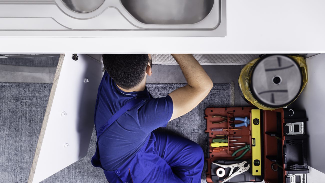 a man fixing a sink, shown from above