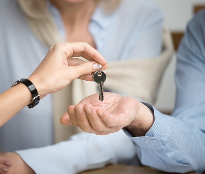 An estate agent handing a key over to a new tenant