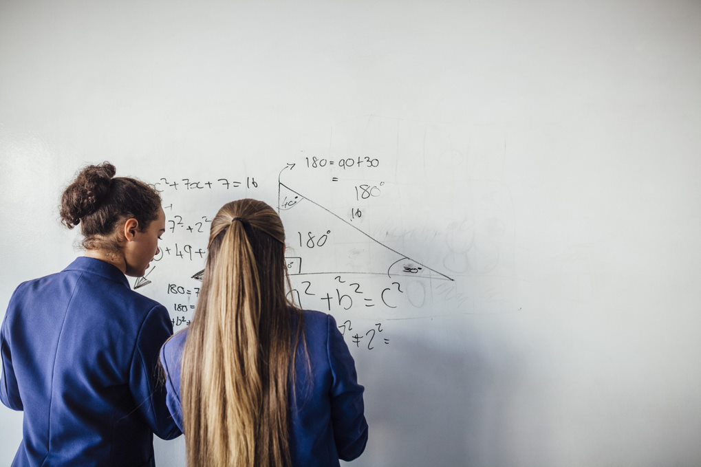 young people writing on whiteboard