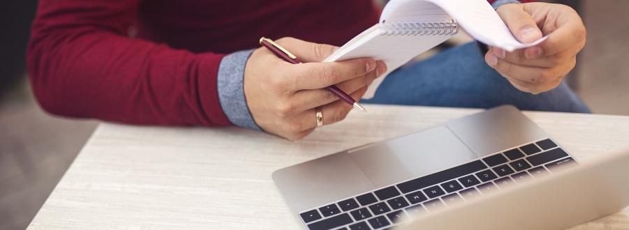 Man Checking Tax Receipts at Laptop