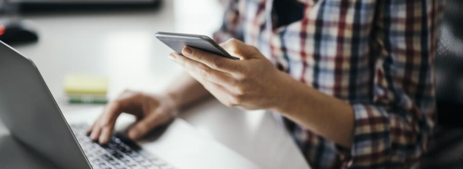 multi-tasking business owner using laptop and phone