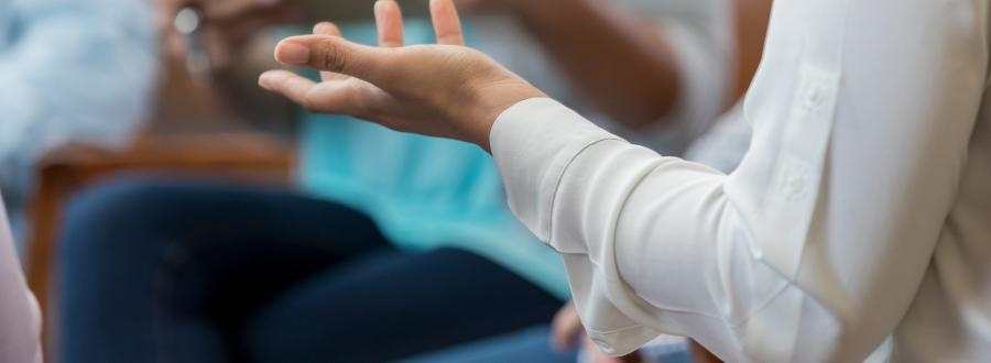 A close up of a woman's arm as she speaks to a group