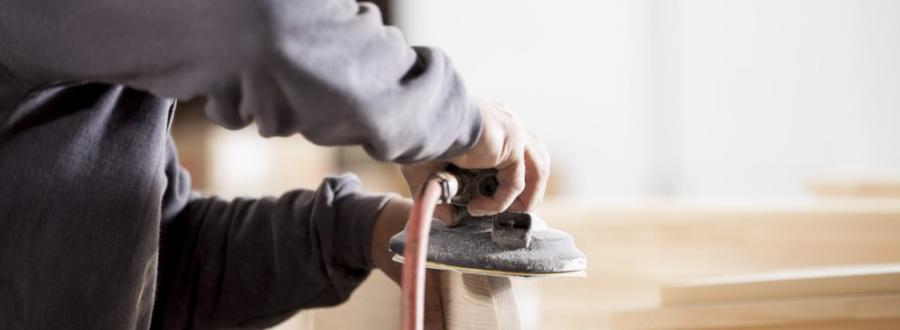 handyman at work sanding wearing goggles