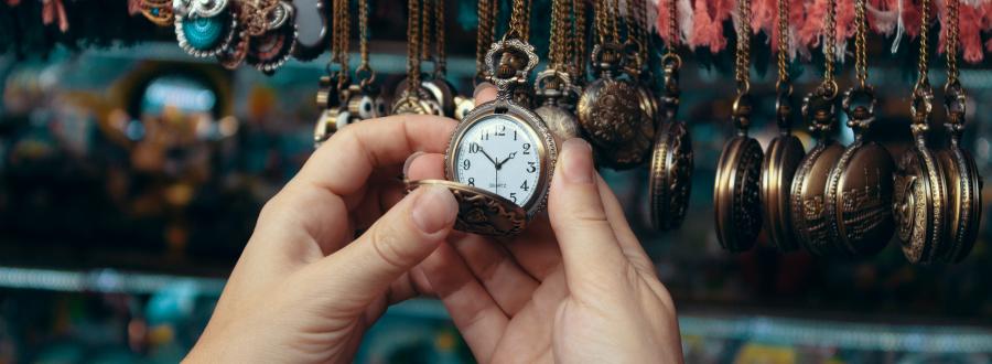 an image showing a hand reaching out to a retail display of watches