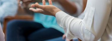 A close up of a woman's arm as she speaks to a group