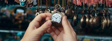 an image showing a hand reaching out to a retail display of watches