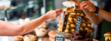 person buying pastries at a counter