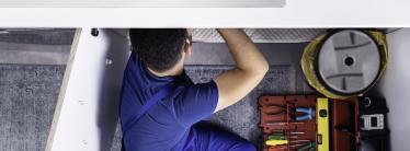 A handyman repairing a sink
