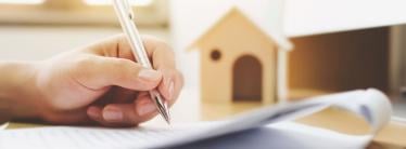 A person signing papers relating to a house