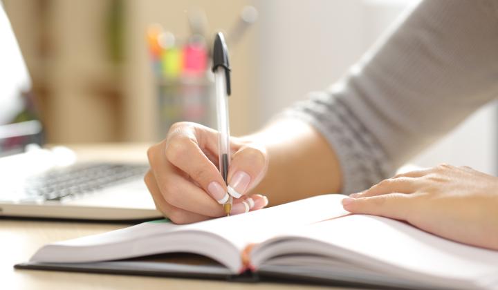 a woman writes in a notebook