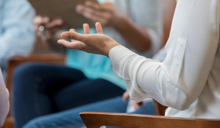 A close up of a woman&#039;s arm as she speaks to a group