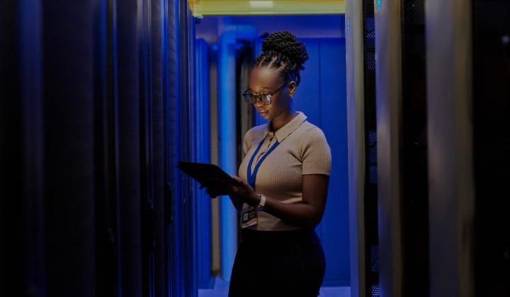 image showing business woman holding laptop in dark room