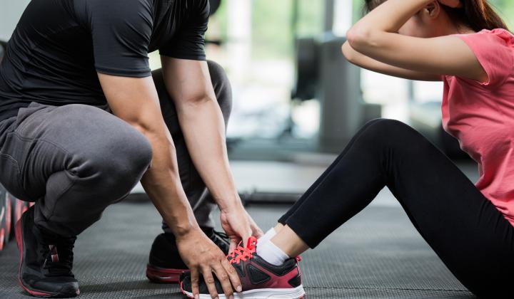 image showing personal trainer guiding client in gym