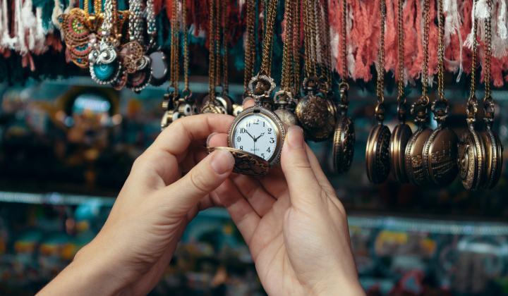 an image showing a hand reaching out to a retail display of watches