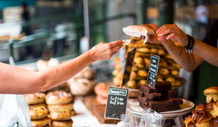 person buying pastries at a counter