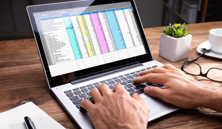 person at laptop with colourful Excel document open