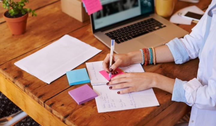 image showing woman writing on notepad
