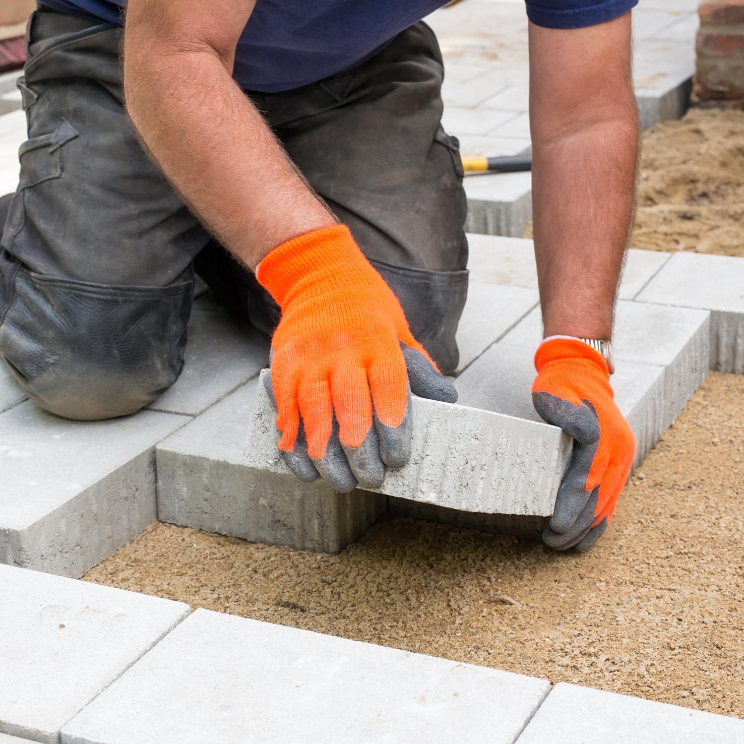 construction employee laying foundation blocks