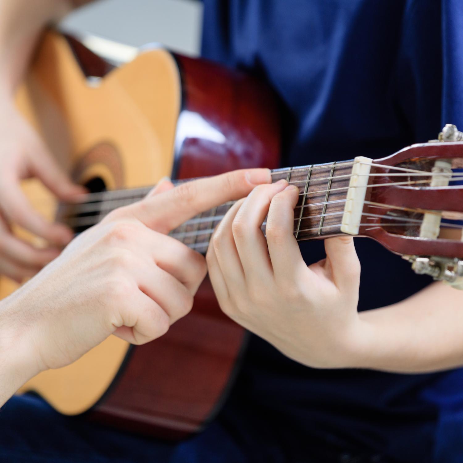 guitar tutor directing learner