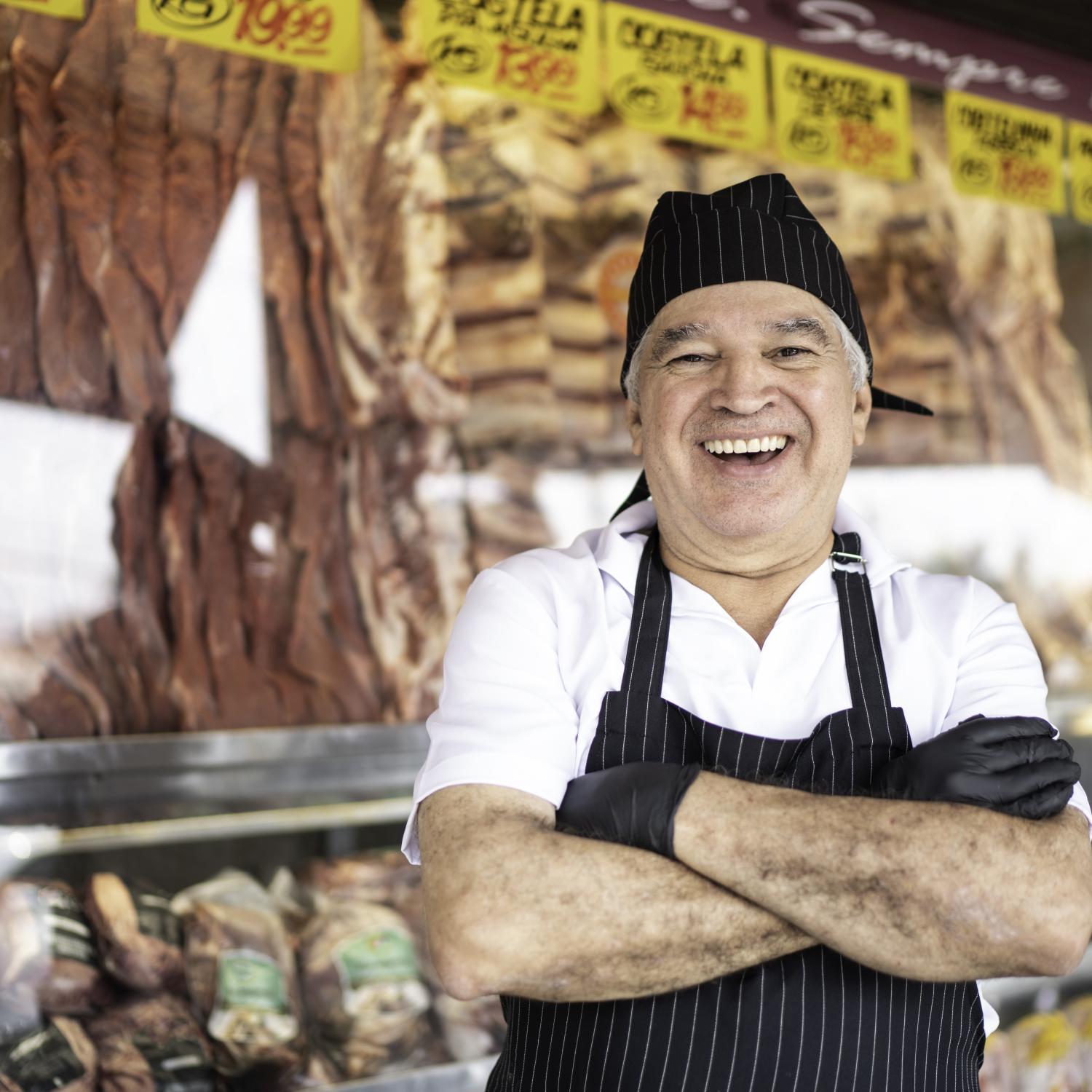 A butcher in front of his shop