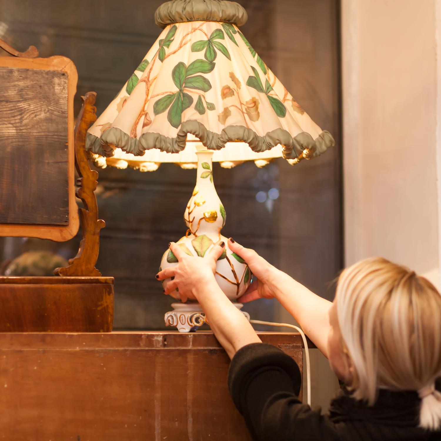 image showing woman placing lamp in furniture shop