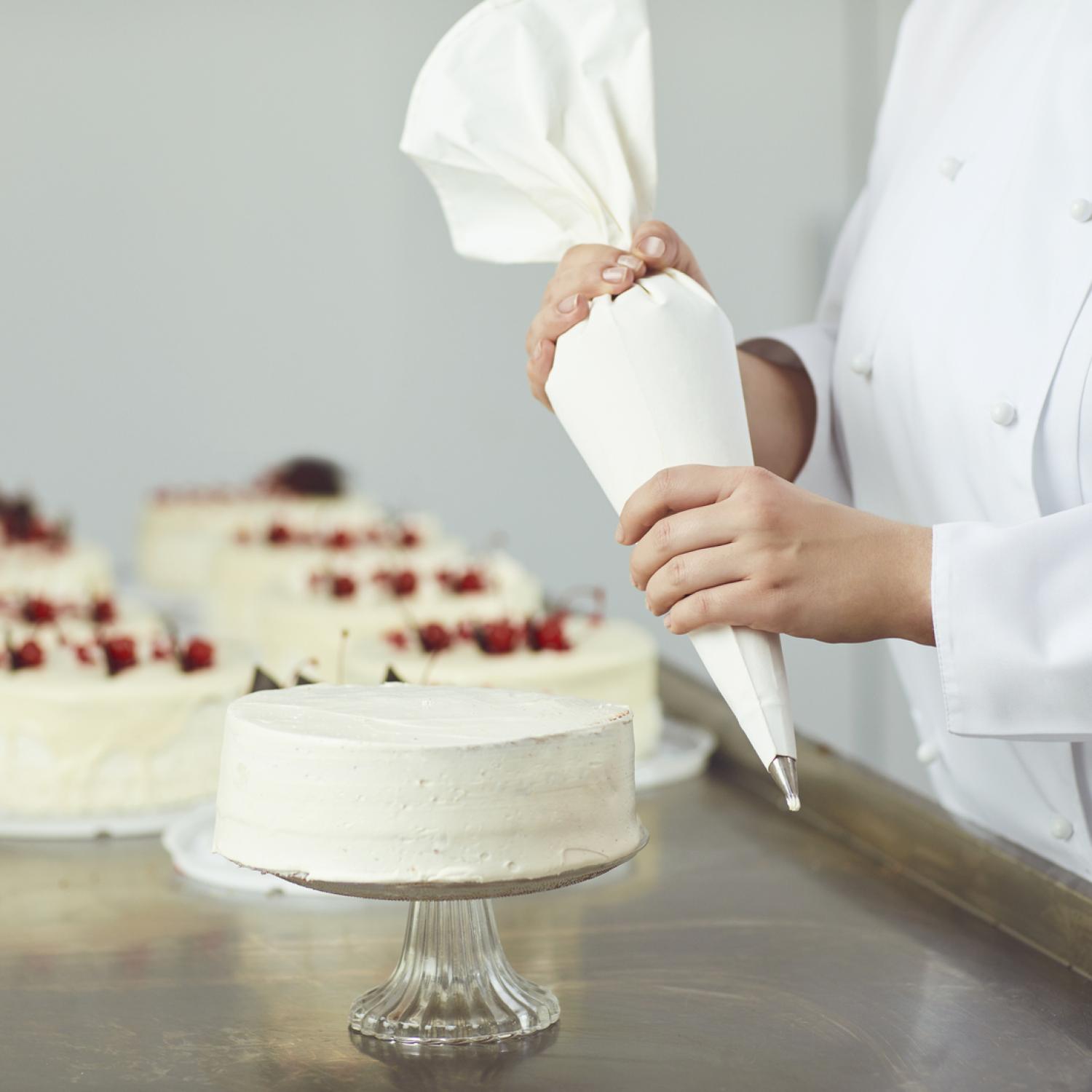 A person decorating a cake