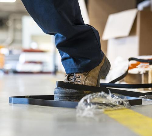 A person about to trip over a hazard in the workplace