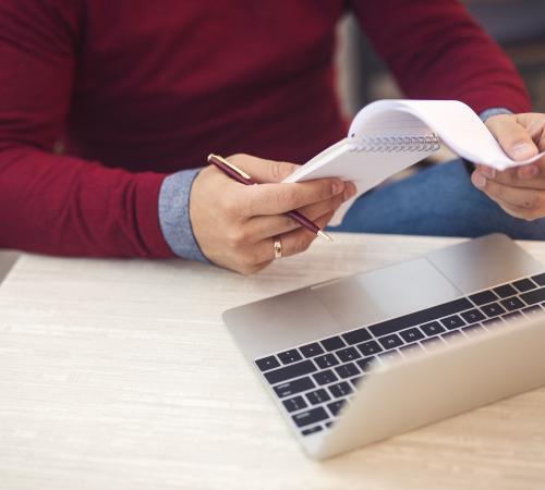 Man Checking Tax Receipts at Laptop