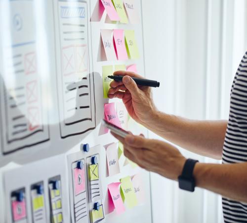 Person writing notes on a whiteboard