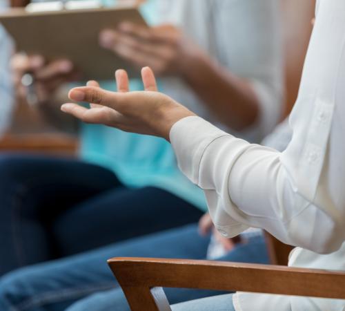 A close up of a woman's arm as she speaks to a group