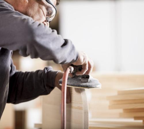 handyman at work sanding wearing goggles