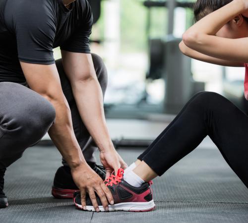 image showing personal trainer guiding client in gym