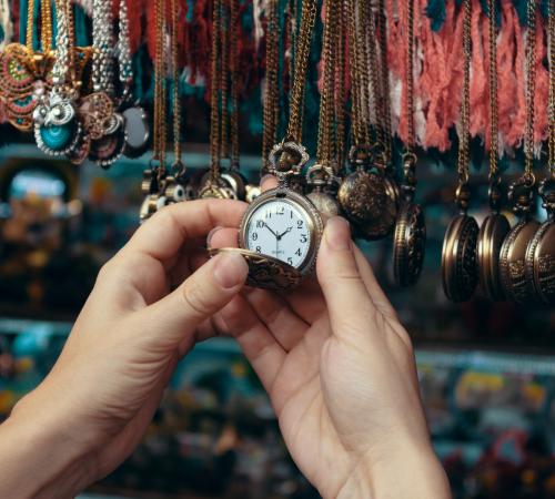 an image showing a hand reaching out to a retail display of watches