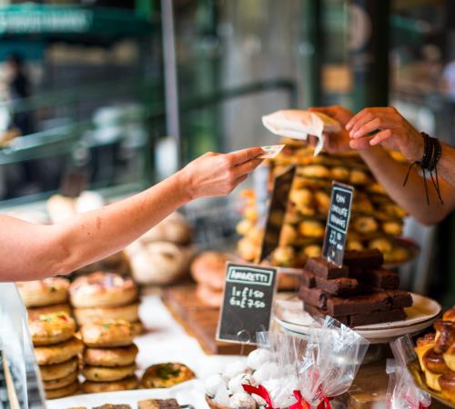person buying pastries at a counter