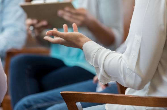 A close up of a woman's arm as she speaks to a group