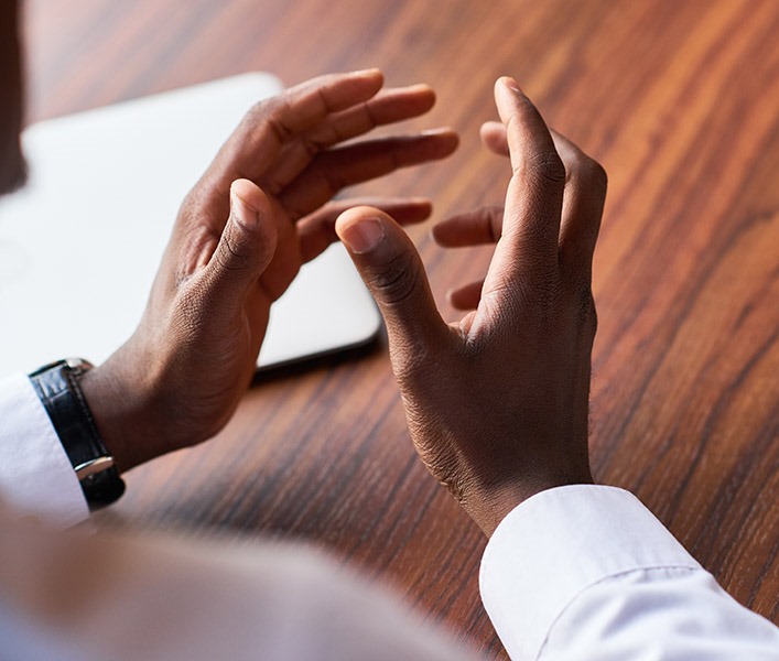 A businessman with his hands stretched out as he speaks to someone
