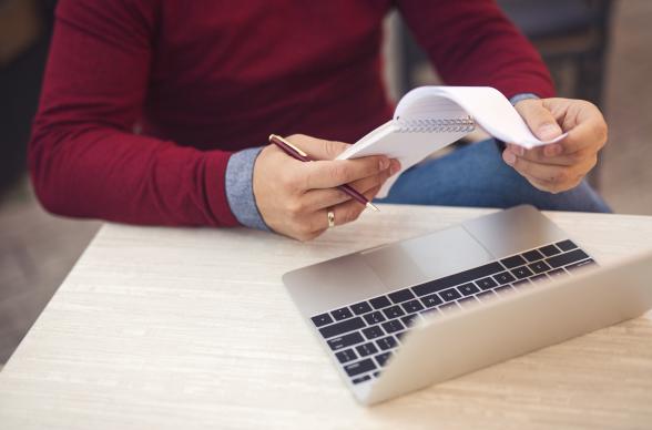 Man Checking Tax Receipts at Laptop
