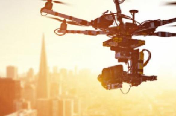 drone flying over cityscape in sunshine