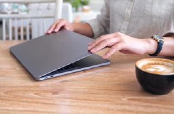 a freelance worker opens laptop in cafe