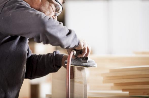 handyman at work sanding wearing goggles